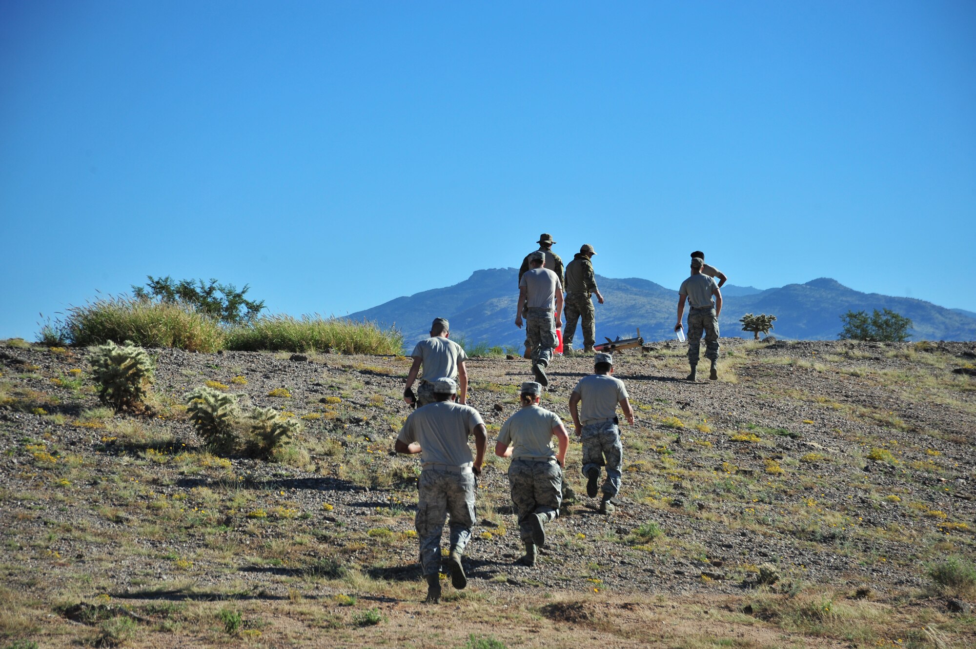 355th Fighter Wing and 162d Fighter Wing Airmen run to their next station during an exercise at Davis-Monthan Air Force Base, Ariz., Oct. 23, 2014.  Six four-member teams comprised of members from bioenvironmental, emergency management and explosive ordnance disposal flights competed against each other to complete 12 tasks in the competition-style exercise modeled after a reality show. (U.S. Air Force Photo by Airman 1st Class Chris Massey/Released)