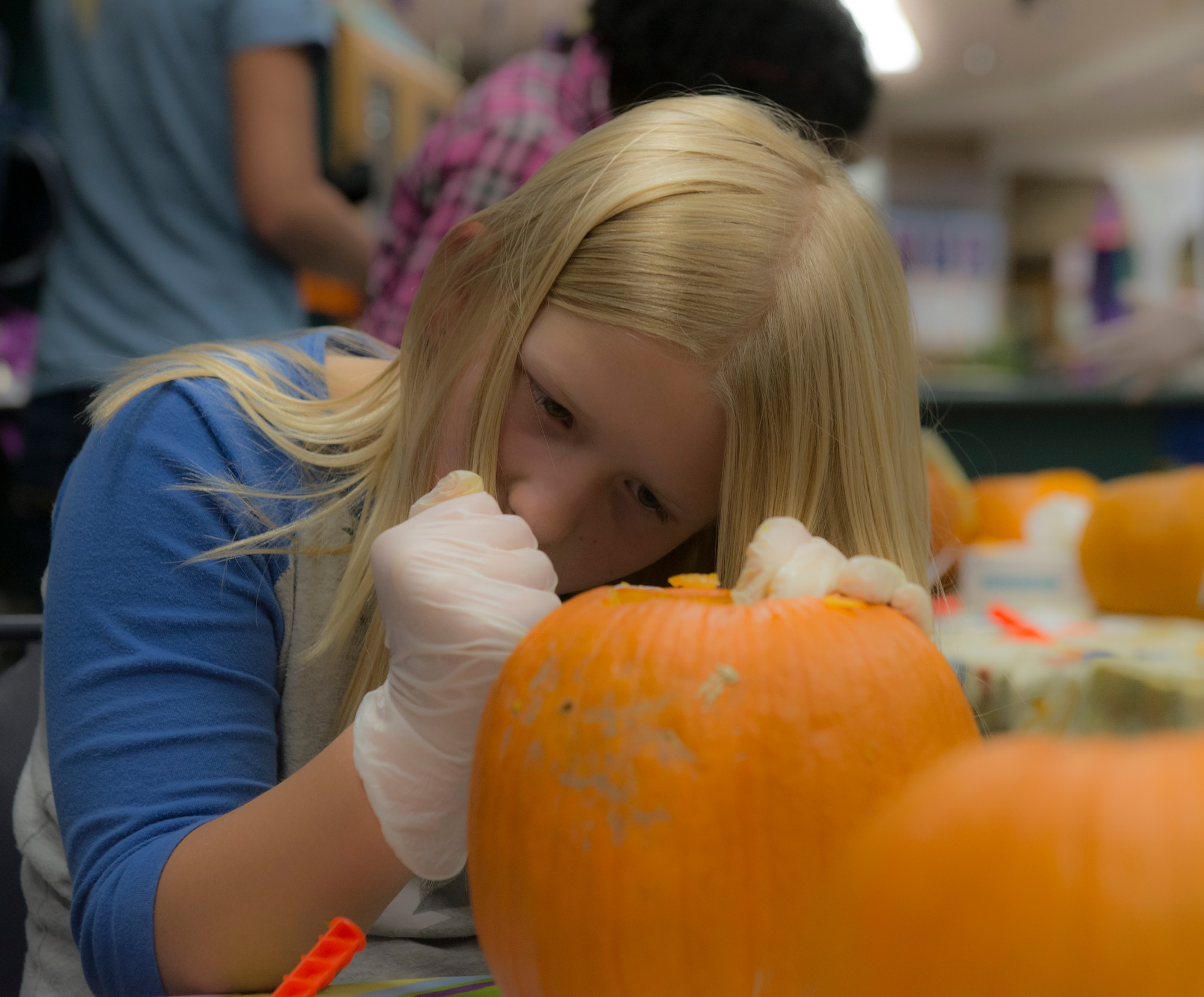Allison Wheeler finishes carving her design into her pumpkin at the Mountain Home Air Force Base, Idaho, Youth Center, Oct. 22, 2014. About 15 children participated in the pumpkin-carving event. (U.S. Air Force photo by Airman 1st Class Jessica H. Smith/RELEASED)