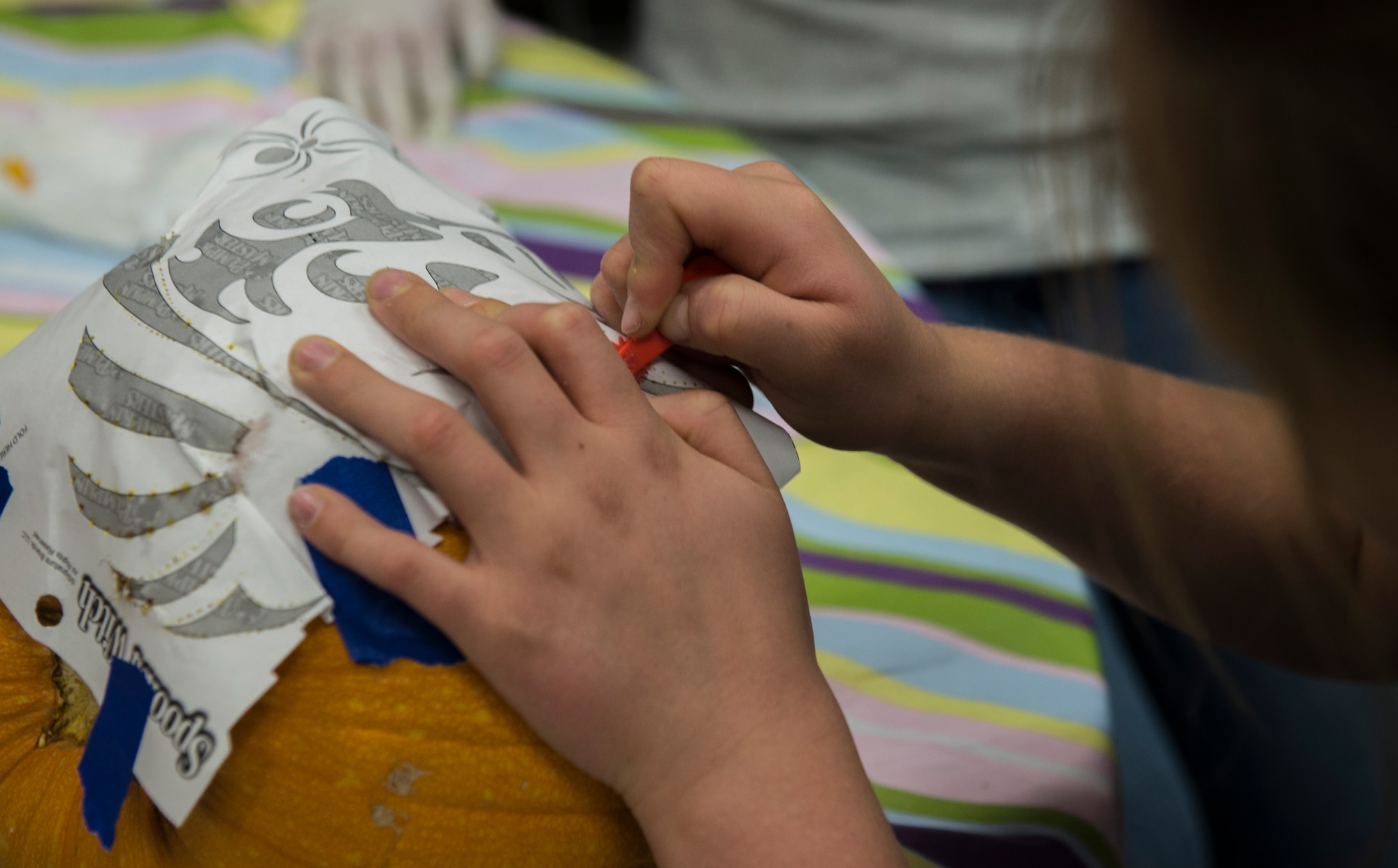 Kaitlyn Harrison concentrates on carving out her pumpkin at the Youth Center at Mountain Home Air Force Base, Idaho, Oct. 22, 2014. Pumpkin-carving is one of many activities the Youth Center offers in celebration of Halloween.  (U.S. Air Force photo by Airman 1st Class Jessica H. Smith/RELEASED)