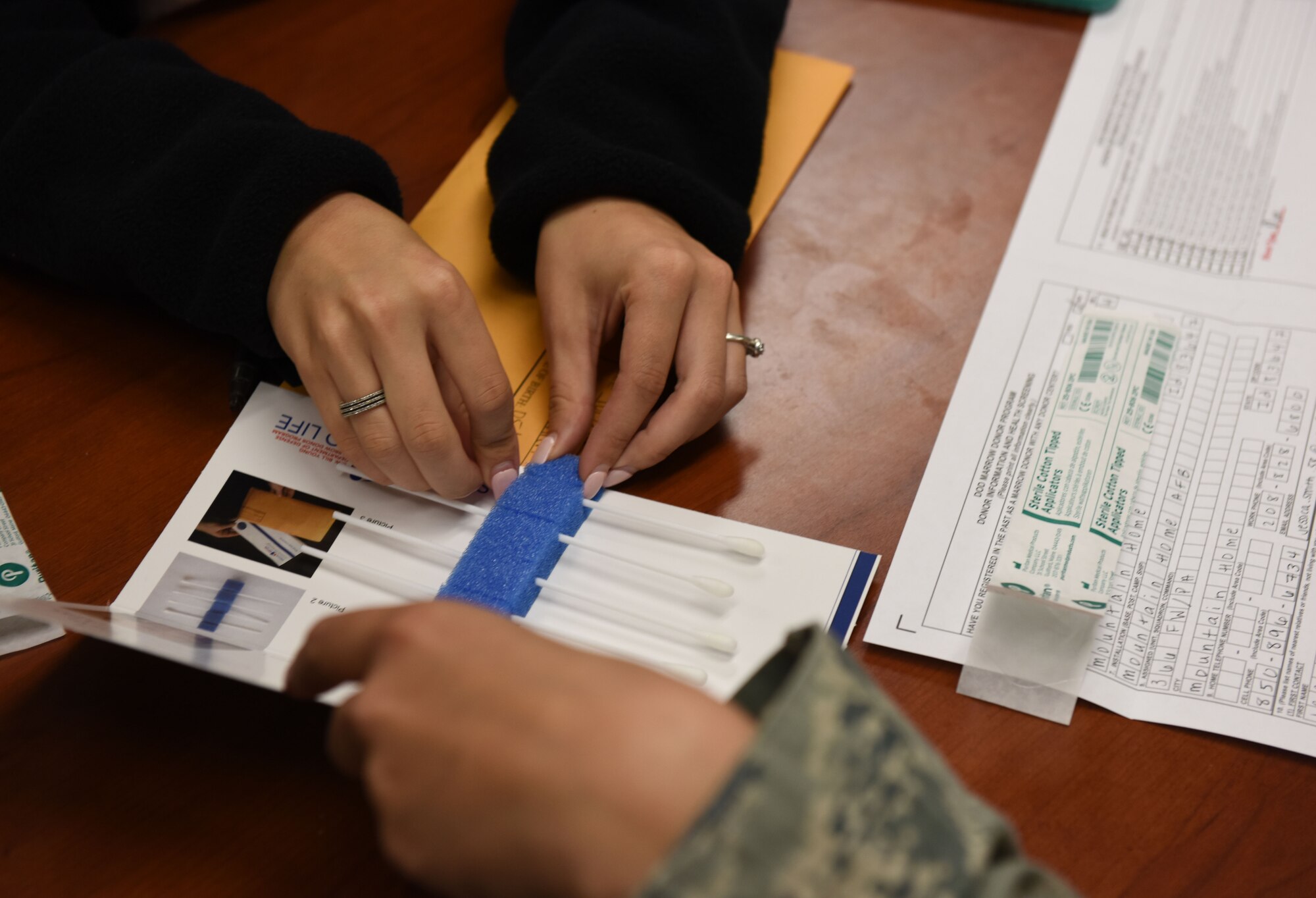 Airman 1st Class Jessica Smith, 366th Fighter Wing Public Affairs photojournalist, places her last swab sample into the carrier to finish the last step of becoming a bone marrow donor Oct. 23, 2014, at Mountain Home Air Force Base, Idaho. Once testing has been performed on the swabs they are placed in the national registry in Minneapolis, Minn., where they will remain until your 61st birthday. (U.S. Air Force photo by Airman 1st Class Jeremy L. Mosier/RELEASED)