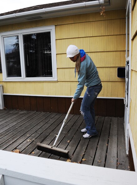 1st Lt. Jennifer Wendland, 341st Maintenance Operations Squadron training flight commander, sweeps leaves off the porch of a local Great Falls, Mont., residence Oct. 24 during the Day of Caring. The Day of Caring is held in conjunction with the Combined Federal Campaign and is held to help elderly and disabled members of the local community with chores they're no longer physically able to do themselves. (U.S. Air Force photo/Christy Mason)