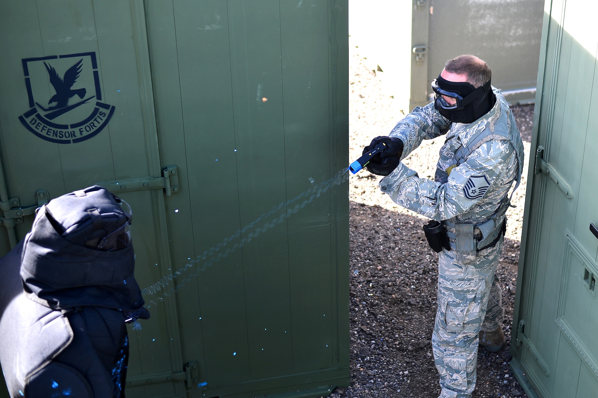 Master Sgt. Don Werkmeister, 140th Security Forces Squadron operations flight sergeant, simulates using a Conducted Electronic Weapon on a suspect during training Oct. 23, 2014, at the 140th SFS building on Buckley Air Force Base, Colo. CEW training is designed to educate law enforcement members on when and how to use non-lethal force in stressful situations. (U.S. Air Force photo by Senior Airman Darren Scott/Released)