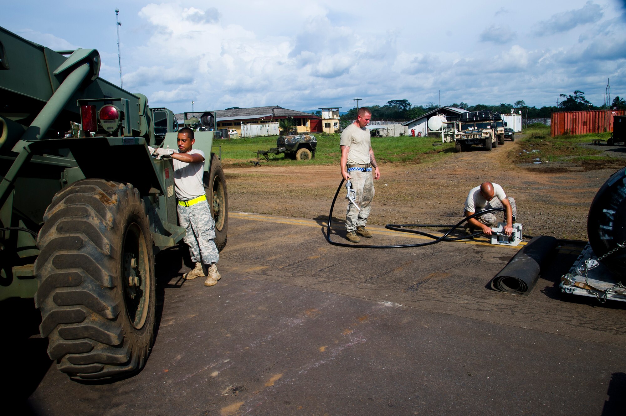 ROBERTS INTERNATIONAL AIRPORT, Republic of Liberia - U.S. Army SPC Michael Gil, 688th Rapid Port Opening Element cargo specialist assigned to Joint Base Langley-Eustis, Va., 621st Contingency Response Wing U.S. Air Force aerial porter Staff Sgt. James Cain, and Staff Sgt. Josh Zanek, electrical power production craftsman, both stationed at Joint Base McGuire-Dix-Lakehurst, N.J., prepare a forklift to be refueled during Operation UNITED ASSISTANCE here, October 17, 2014. The Airmen and Soldier are a part of the Joint Task Force Port-Opening team that consists of approximately 79 members of the CRW and 10 Soldiers from the RPOE. (U.S. Air Force photo/Staff Sgt. Gustavo Gonzalez/RELEASED)