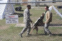 Staff Sgt. Sharif DeLarge, Staff Sgt. Matthew Liimakka, 802nd Security Forces Squadron military working dog handlers, and military working dog Rocco show how effective military working dogs can be at apprehending criminals during a 502nd Air Base Wing Honorary Commanders’ Immersion tour Oct. 10, 2014 at Joint Base San Antonio-Lackland. Honorary commanders toured locations at JBSA-Lackland and JBSA-Camp Bullis to get a better understanding of the missions that take place at the two locations, and to build a stronger bond between the local community and the military. (U.S. Air Force photo by Airman 1st Class Stormy Archer/Released)