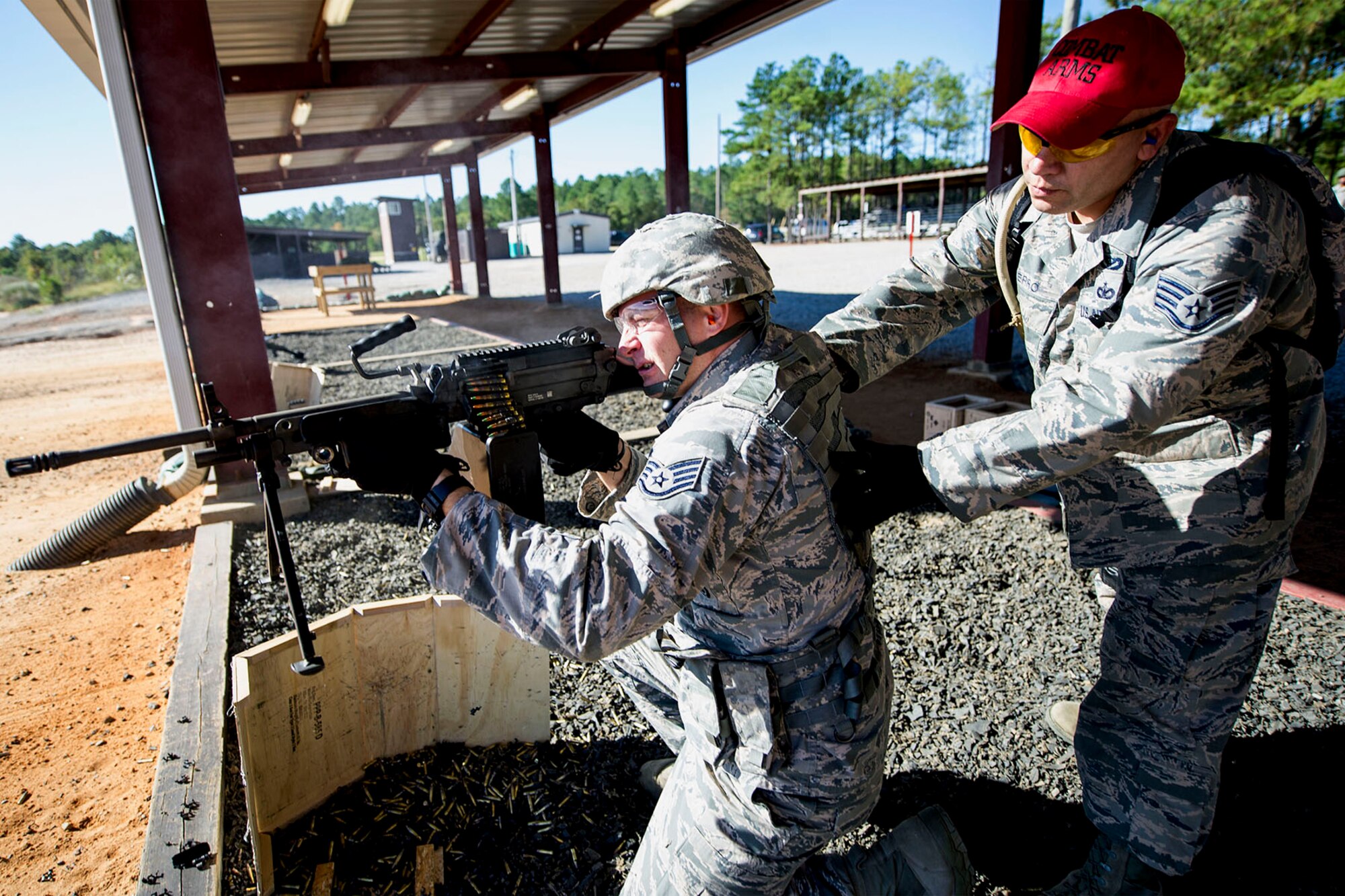 U.S. Air Force Staff Sgt. Eric Heximer, an operations non-commissioned officer, assigned to the 169th Security Forces Squadron at McEntire Joint National Guard Base, S.C., fires the M249 light machine gun kneeling as Staff Sgt. Ismael Fierro, combat arms instructor, looks on during heavy weapons training at Fort Jackson, S.C., Oct. 5, 2014. Routine weapons training ensures Airmen of the South Carolina Air National Guard are trained and prepared to perform their mission at home and abroad.   (U.S. Air National Guard photo by Tech. Sgt. Jorge Intriago/Released)