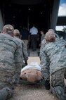 Staff Sgt. Nick Yankosky, Staff Sgt. Jessica Rumsley, Staff Sgt. Vanessa Barton and Staff Sgt. Jocelyn Frenyea, 937th Training Support Squadron Medical Readiness Training Center instructors, prepare to demonstrate how to carry a patient litter onto a C-130 Hercules during a 502nd Air Base Wing Honorary Commanders’ Immersion Tour Oct. 10, 2014 at JBSA-Camp Bullis. Honorary commanders toured locations at JBSA-Lackland and JBSA-Camp Bullis to get a better understanding of the missions that take place at the two locations, and to build a stronger bond between the local community and the military. (U.S. Air Force photo by Airman 1st Class Stormy Archer/Released)