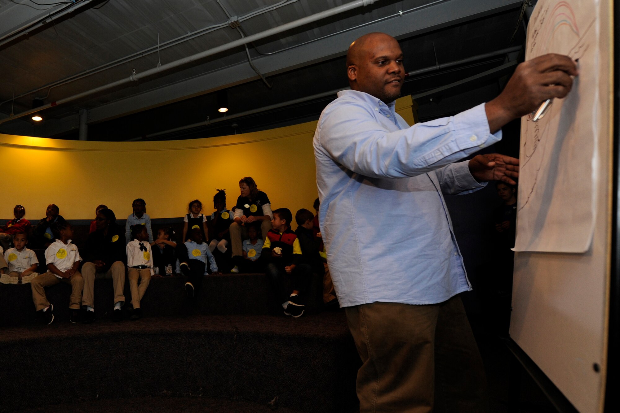 R. Gregory Christie, award winning children’s illustrator, draws a picture during his presentation about his work for youth center children on Joint Base Andrews, Md., Oct 24, 2014. JBA youth received free copies of his books through the Reading Is Fundamental program, the largest children’s literacy nonprofit organization in the United States. (U.S Air Force photo/ Senior Airman Nesha Humes)