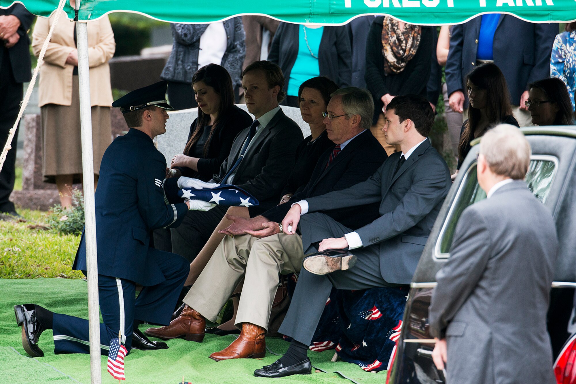 A member of the Barksdale Air Force Base Honor Guard presents an American Flag to Will McCrocklin during the funeral service for his father, Claude McCrocklin, Oct. 23, 2014, Shreveport, La. McCrocklin, a World War II B-24 bombardier and Prisoner of War, died Oct. 18, 2014, after a lengthy illness. He was 93. (U.S. Air Force photo by Master Sgt. Greg Steele/Released)