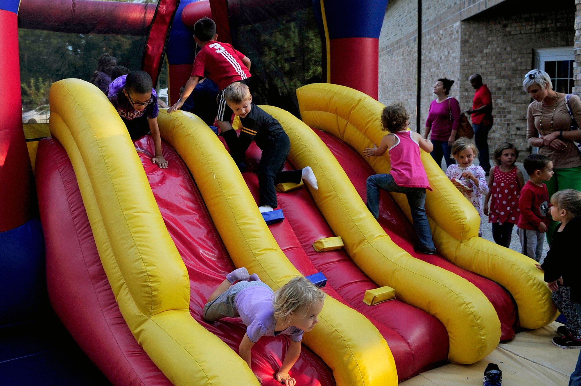 Team Seymour kids climb on a bouncy house during a “Hearts Apart” event Oct. 24, 2014, at Seymour Johnson Air Force Base, North Carolina. The event focused on relieving the pressures families sustain when a member is deployed and served as a venue to ensure families are connected with the wing’s many helping agencies and resources. (U.S. Air Force photo/Airman 1st Class Shawna Keyes)