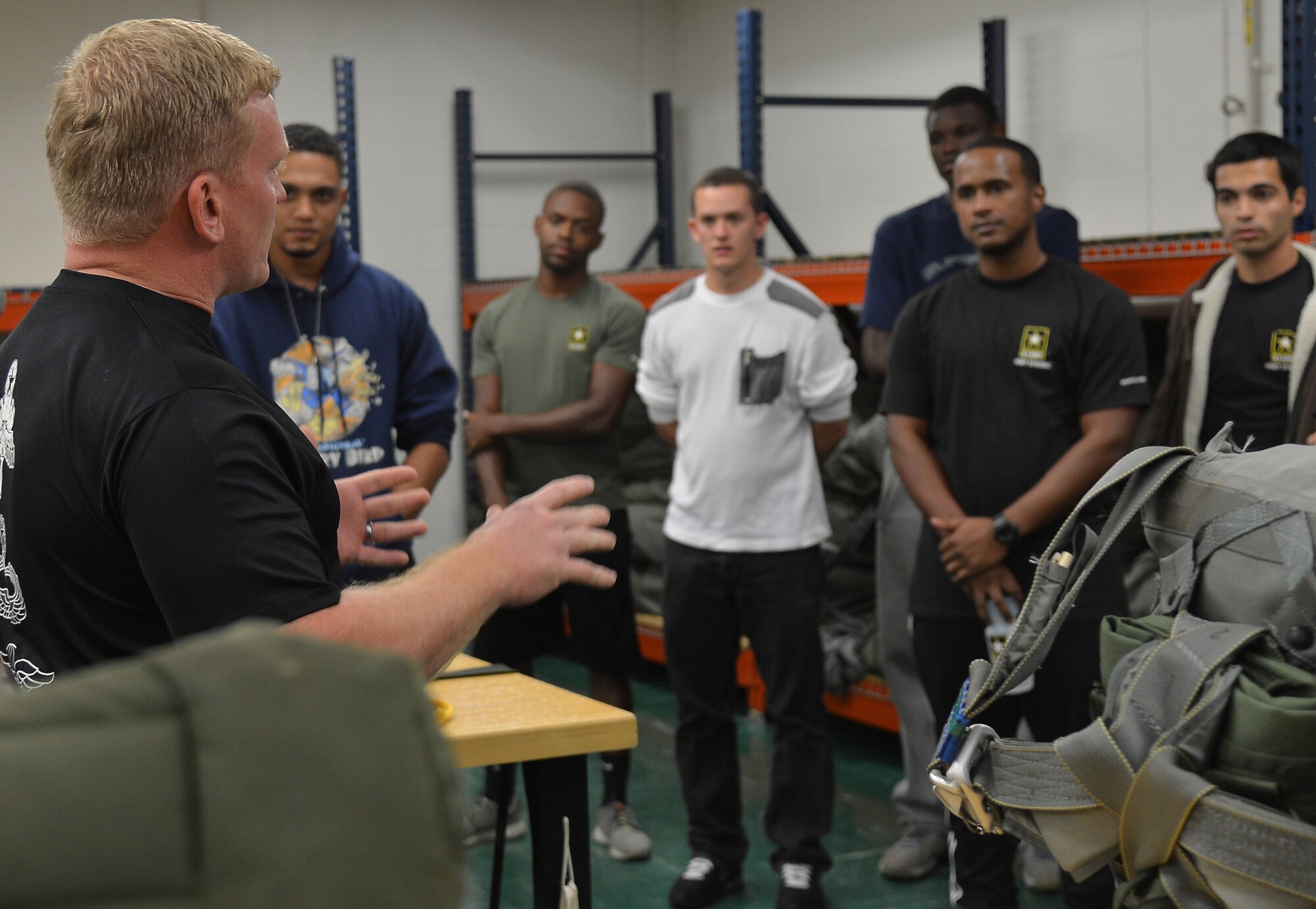 Staff Sgt. Tellef Klemetson, Joint Communications Support Element parachute rigger, briefs the future soldiers from the Orlando Recruiting Company during the Army Recruiting Future Soldiers Event Oct. 17, 2014 at MacDill Air Force Base, Fla. The parachute riggers set up three simulators with different landing styles for the future soldiers to try after a briefing was given about their mission and safety. (U.S. Air Force photo by Senior Airman Jenay Randolph/Released)