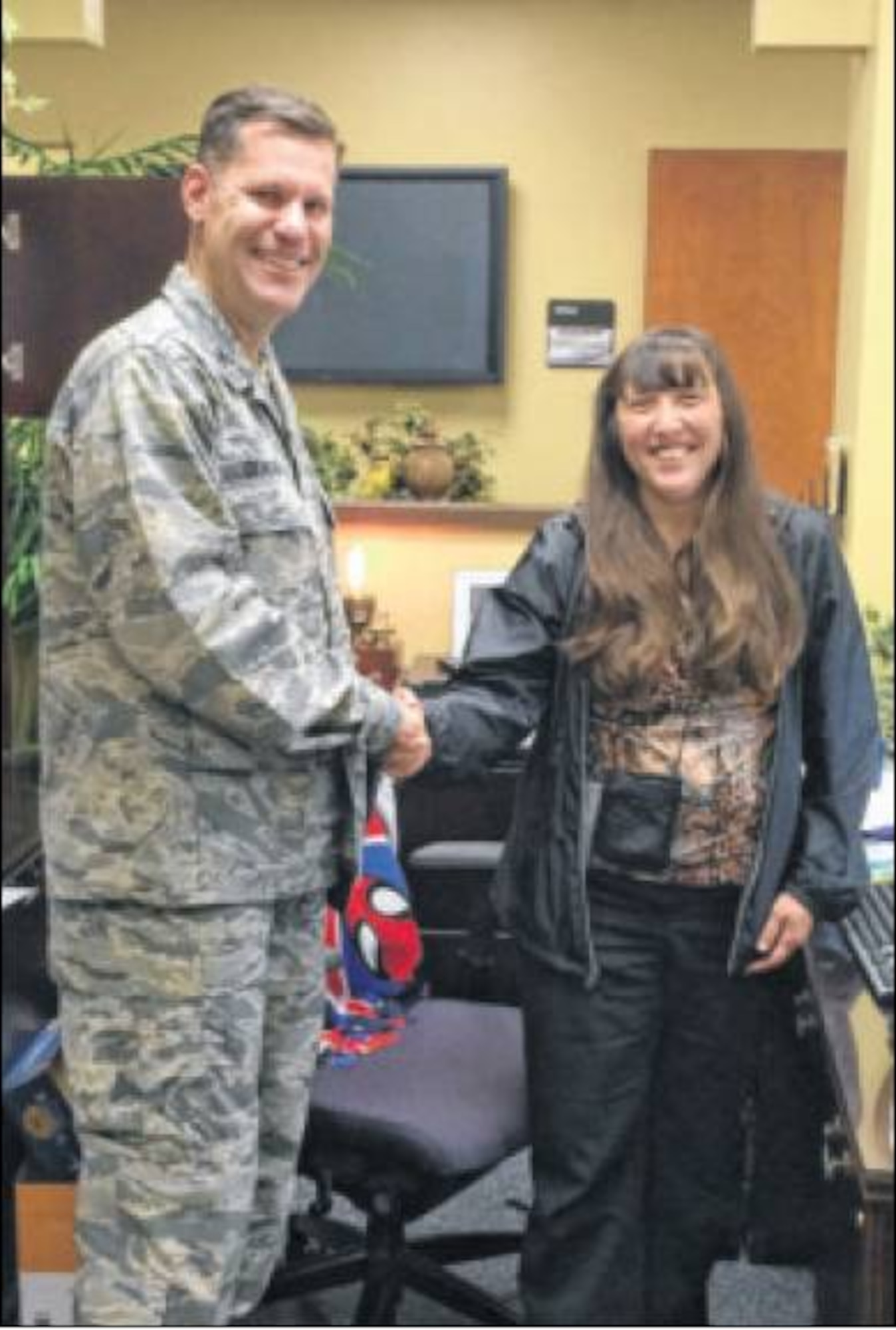 Col. John Devillier, 88th Air Base Wing commander, presents the first wingman’s coin to Theresa Werling, coin designer. (Contributed photo)