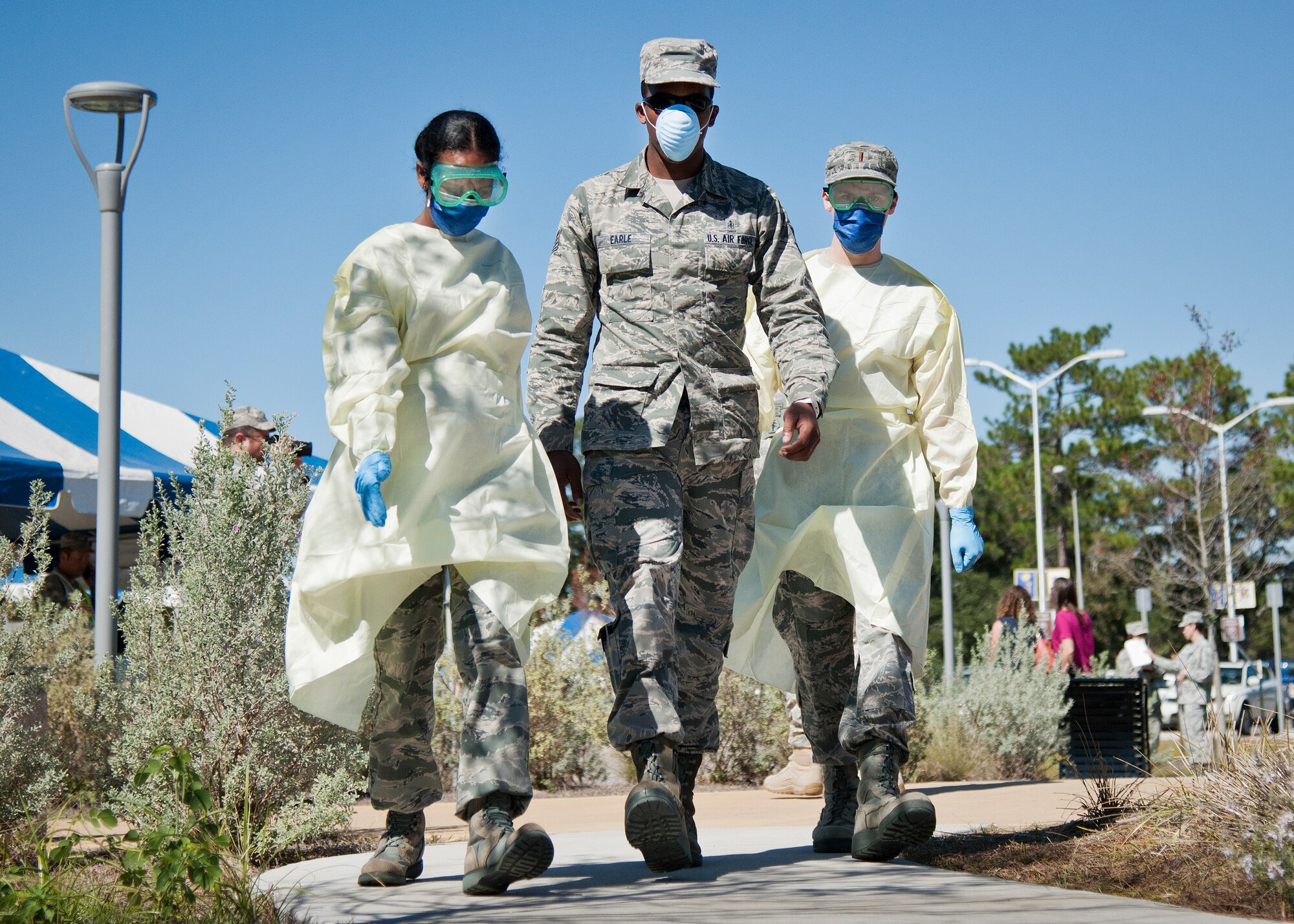 A simulated ebola-infected victim is escorted toward a quarantine zone during a disease containment exercise at Eglin Air Force Base, Fla., Oct. 22.  The base’s medical personnel performed the specific procedures required in the event of an outbreak in the local area and on base.  (U.S. Air Force photo/Samuel King Jr.)