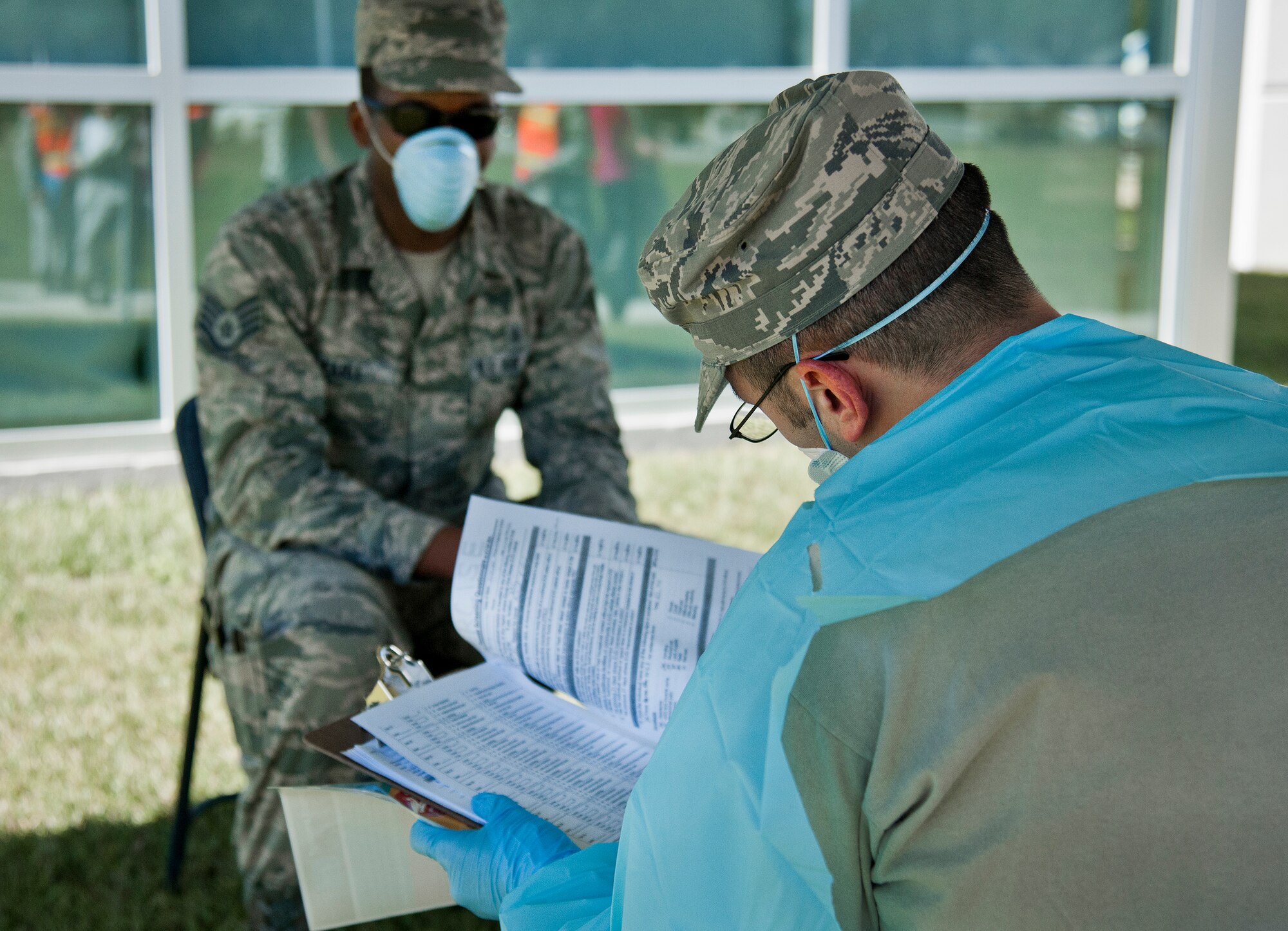 A 96th Medical Group Airman interviews a simulated ebola-infected victim during a disease containment exercise at Eglin Air Force Base, Fla., Oct. 22.  The base’s medical personnel performed the specific procedures required in the event of an outbreak in the local area and on base.  (U.S. Air Force photo/Samuel King Jr.)