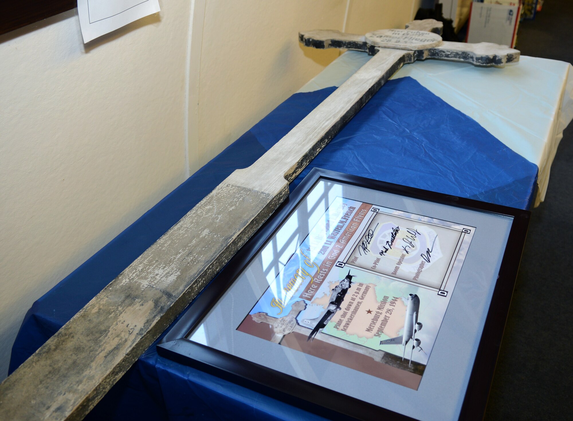 A grave marker memorializing two 100th Bombardment Group Airmen, U.S. Army Air Corps 1st Lt. Raymond Harney, a B-17 Flying Fortress pilot, and his bombardier U.S. Army Air Corps 2nd Lt. Warren French, rests on a table along with a certificate commemorating it Oct. 24, 2014, at Thorpe Abbotts near Diss, England. Base leadership traveled to Thorpe Abbotts to return the grave marker originally from Germany memorializing the two Airmen, as well as to discuss wing improvement strategies. (U.S. Air Force photo by Airman 1st Class Dillon Johnston/Released)