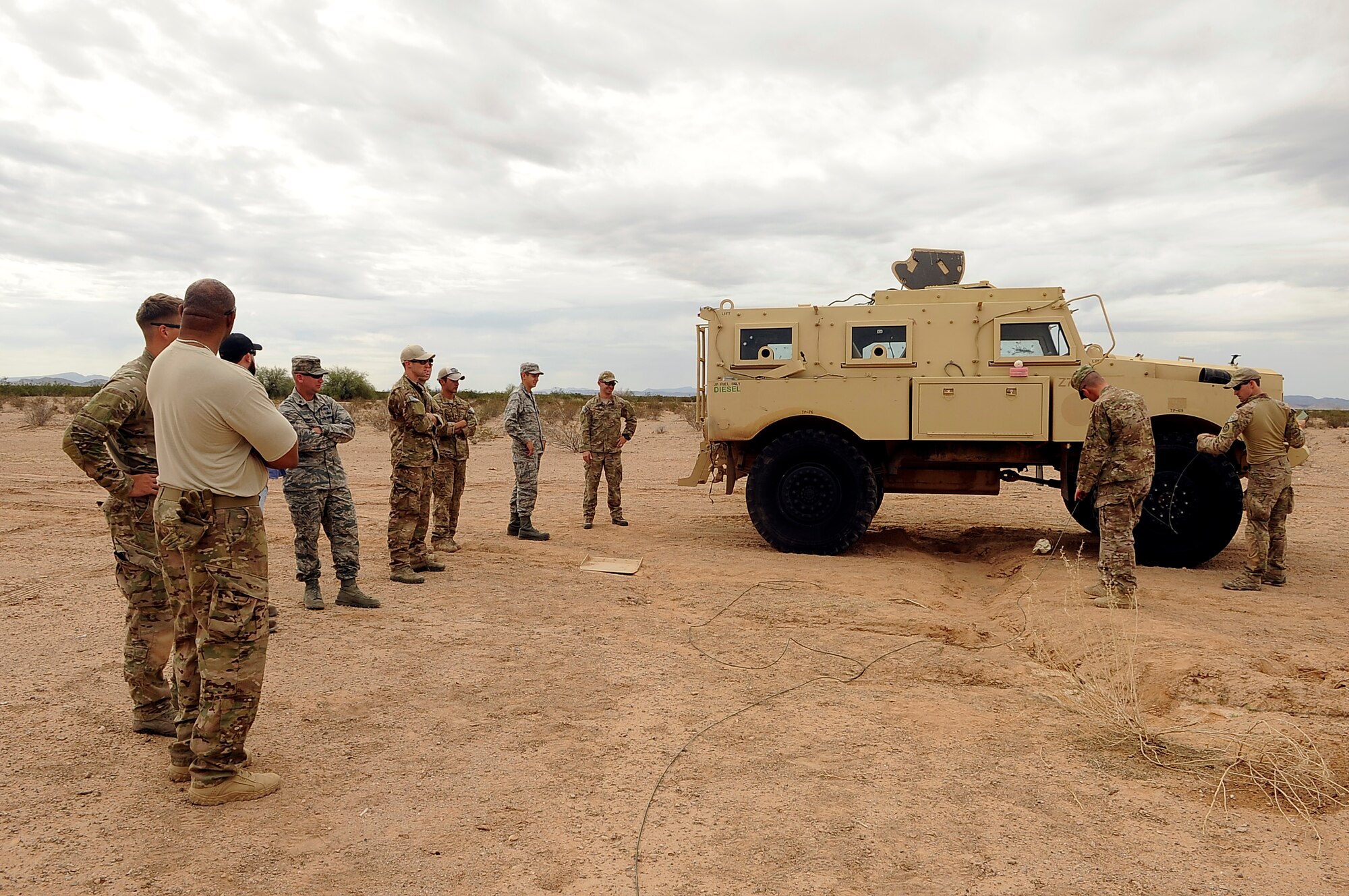 Chief Master Sgt. William Ewing, 56th Civil Engineer Squadron Explosive Ordnance Disposal flight chief, and Staff Sgt. Michael Garrison, 56th CES EOD training coordinator, brief the Airmen on the preparation for a life-like explosion Oct. 7 at Barry M. Goldwater Range. EOD detonated a 50-pound charge beneath a Mine Resistant Ambush Protection vehicle to demonstrate a post blast analysis on a vehicle struck by an improvised explosive device. (U.S. Air Force photo/Airman 1st Class Pedro Mota)