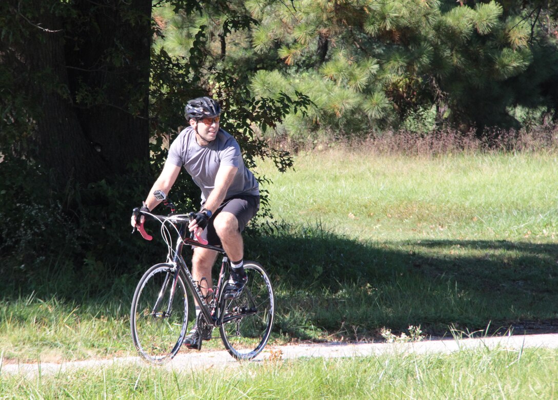 Col. Karl Goerke, 932nd Airlift Wing commander and biking enthusiast, checks an intersecting road to his left as he rides around Scott Air Force Base during a exercise workout and preparation for a video podcast segment.  He noted he always wears a helmet and special gloves and protective shoes while riding during the day.  (U.S. Air Force photo/Maj. Stan Paregien)