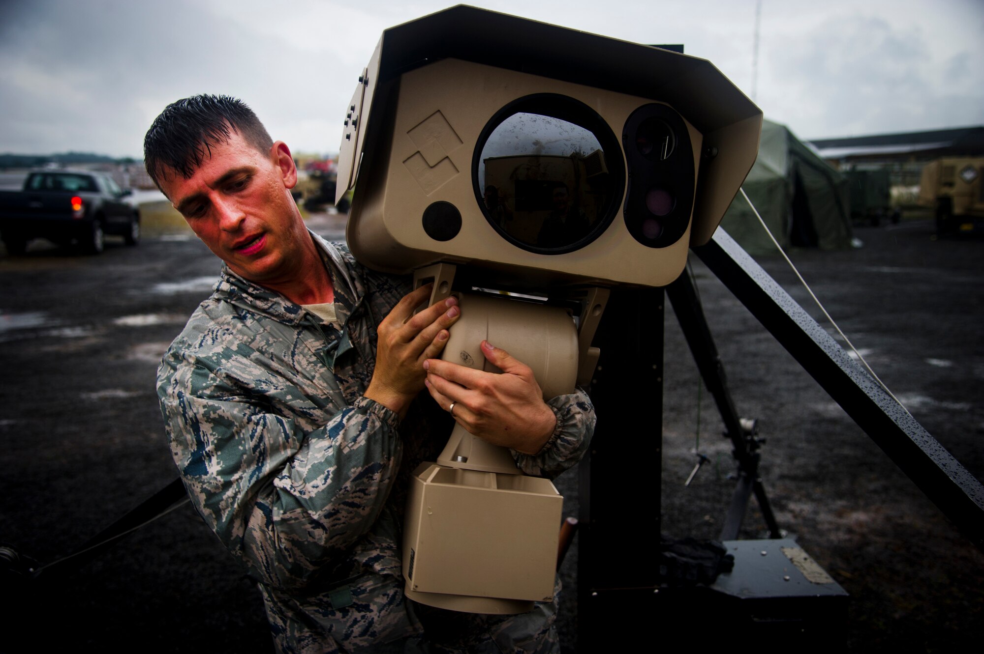 ROBERTS INTERNATIONAL AIRPORT, Republic of Liberia - Tech. Sgt. Arthur Dennis, 621st Contingency Response Wing security forces member, carries a surveillance camera to be installed during Operation UNITED ASSISTANCE here, Oct 13, 2014. The cameras will help secure the airfield and DoD assets during OUA. (U.S. Air Force photo by Staff Sgt. Gustavo Gonzalez/RELEASED)