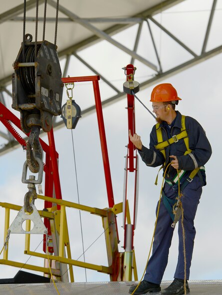 Dustin Vanderheyden, C-130 strip crew, gives directions to the crane
operator during disassembly of the flaps. U.S. Air Force photo by Ed Aspera