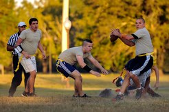 Staff Sgt. Jonathan Haney, 437th Aircraft Maintenance Squadron dedicated crew chief, sets up to throw while Airman 1st Class Ulises Zamora, 437th AMXS crew chief (left) and Staff Sgt. Williams McDevitt, 437th AMXS instrument and flight controls systems technician, provide coverage during the first Air Base intramural flag football game of the season Oct. 21, 2014, at Joint Base Charleston, S.C. The 628th Civil Engineer Squadron beat AMXS 24-14. (U.S. Air Force photo/Staff Sgt. Renae Pittman)