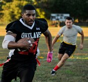 Senior Airman Ryan Galbrieth, 628th Civil Engineer Squadron structural technician, runs the ball past 437th Aircraft Maintenance Squadron defenders  Airman 1st Class Mohamed Alzer (left) and Senior Airman Kevin Medina, during an intramural flag football game Oct. 21, 2014, at Joint Base Charleston, S.C. The 628th CES won 24-14. (U.S. Air Force photo/Staff Sgt. Renae Pittman)