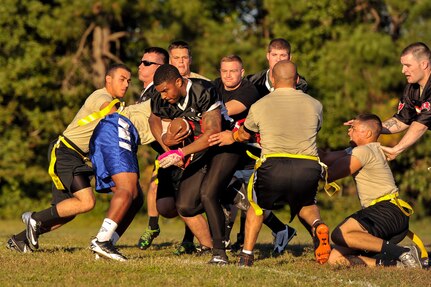 Senior Airman Ryan Galbreith, 628th Civil Engineer Squadron structural technician, powers through the 437th Aircraft Maintenance Squadron defensive line during an intramural flag football game Oct. 21, 2014, at Joint Base Charleston, S.C. The 628th CES won 24-14. (U.S. Air Force photo/Staff Sgt. Renae Pittman)