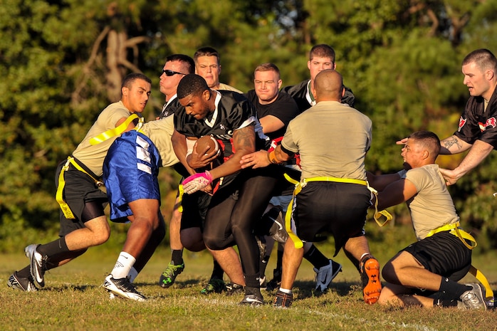 Senior Airman Ryan Galbreith, 628th Civil Engineer Squadron structural technician, powers through the 437th Aircraft Maintenance Squadron defensive line during an intramural flag football game Oct. 21, 2014, at Joint Base Charleston, S.C. The 628th CES won 24-14. (U.S. Air Force photo/Staff Sgt. Renae Pittman)