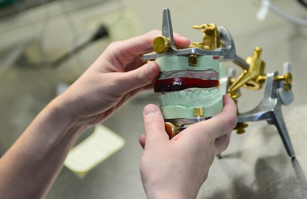 Staff Sgt. Maygan Gipson, 28th Medical Operation Squadron dental laboratory technician, forms a mouth guard on a patient’s dental impression at Ellsworth Air Force Base, S.D., Oct. 17, 2014. The lab uses molds of patients’ teeth to create approximately 60 mouthguards per month. (U.S. Air Force photo by Senior Airman Zachary Hada/Released)