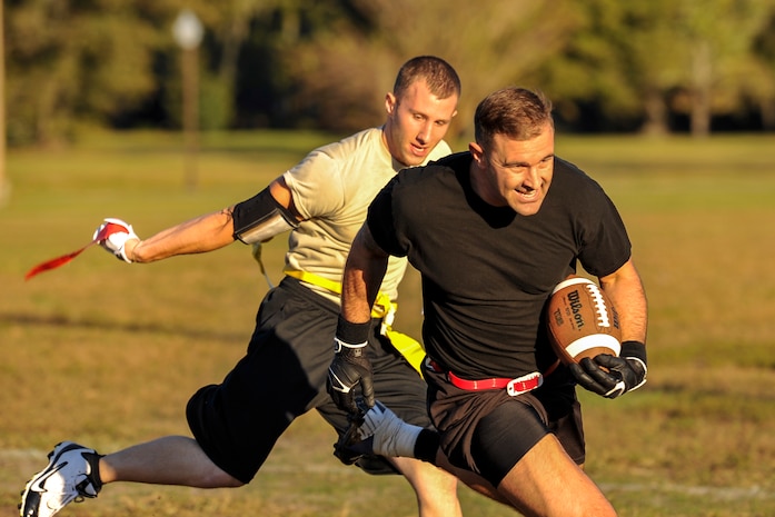 Senior Airman Nathan Hooven, 437th Aircraft Maintenance Squadron dedicated crew chief, grabs the flag off of Senior Airman Garrett Busk, 628th Civil Engineer Squadron HVAC technician, during an intramural football game Oct. 21, 2014, at Joint Base Charleston, S.C. The 628th Force Support Squadron runs multiple intramural leagues to include flag football, softball and volleyball throughout the year. (U.S. Air Force photo/Staff Sgt. Renae Pittman)