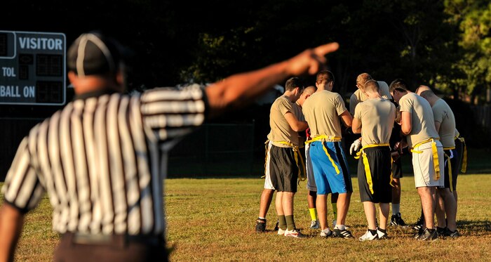 Referee Sam Mathis directs the 437th Aircraft Maintenance Squadron intramural flag football team to take their positions during the Air Base intramural football season opener Oct. 21, 2014, at Joint Base Charleston, S.C. The 437th AMXS lost to the 628th Civil Engineer Squadron 14 to 24. Each Air Base intramural team will play 13 games prior to the championship scheduled for early December. (U.S. Air Force photo/Staff Sgt. Renae Pittman)