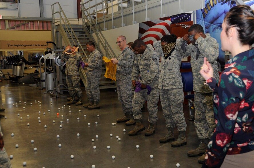 Military and Family Life Consultant Nicole Replogle, explains the instructions for the golf ball minefield exercise during Air Force Mortuary Affairs Operations Wingman Day Oct. 23, 2014. The exercise was an opportunity to see how diversity can help people achieve their goals. (U.S. Air Force photo/Tech. Sgt. Joy Meek) 