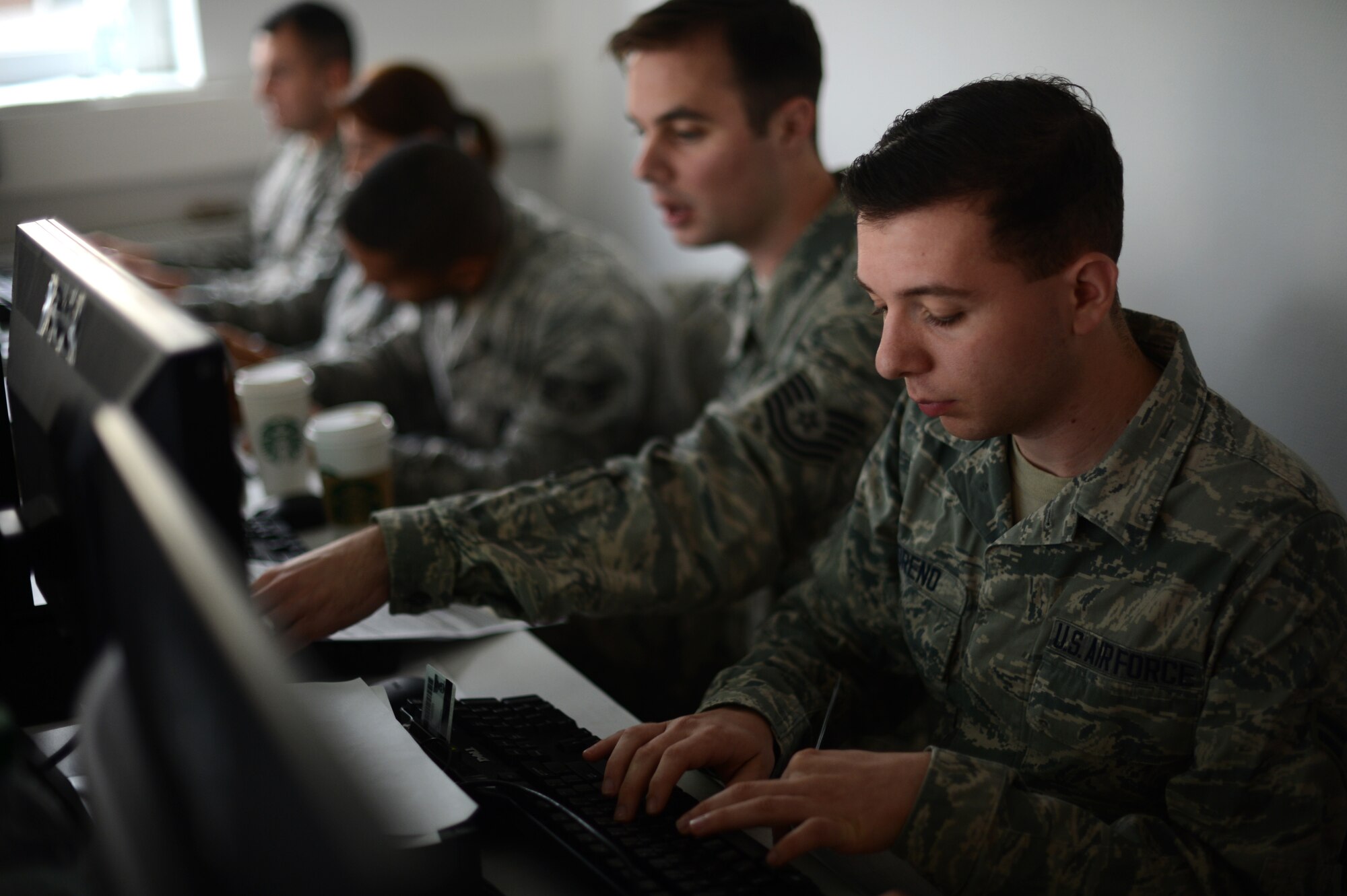 Members of the 52nd Medical Group transcribe statistics into computers at the Skelton Memorial Fitness Center at Spangdahlem Air Base, Germany, Oct. 23, 2014. Vaccine recipients needed to fill out paperwork prior to the event for accountability purposes. The 52nd MDG technicians uploaded the information to allow a real-time report of the Airmen to unit commanders. (U.S. Air Force photo by Senior Airman Gustavo Castillo/Released) 