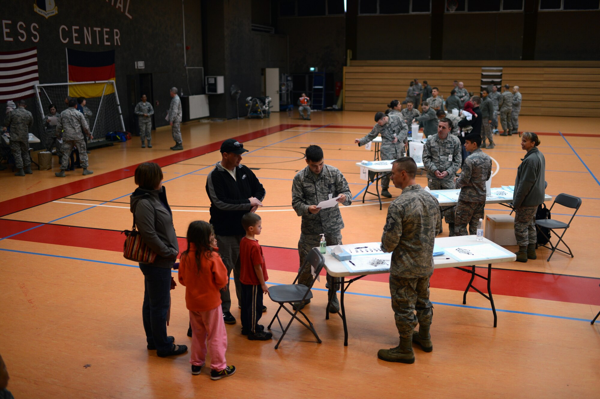 Airmen from the 52nd Medical Group administer a flu vaccine to members of the Spangdahlem community inside the Skelton Memorial Fitness Center at Spangdahlem Air Base, Germany, Oct. 23, 2014. The mass vaccination demonstrated the wing’s capability to protect the base population in the event of a disease threat or outbreak. (U.S. Air Force photo by Senior Airman Gustavo Castillo/Released) 