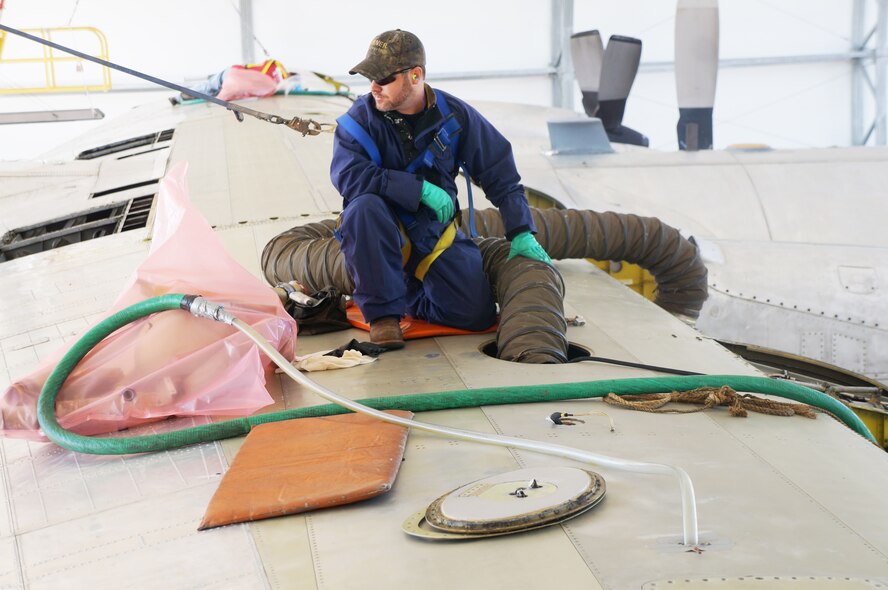 Robert Noles, part of the C-130 strip crew, removes fuel foam from the inside of a right wing cavity. On some areas of the wing, workers are able to open a lid and effortlessly extract the material. But, there are other areas where crews must crawl inside the wing to get the job done. U.S. Air Force photo by Ed Aspera