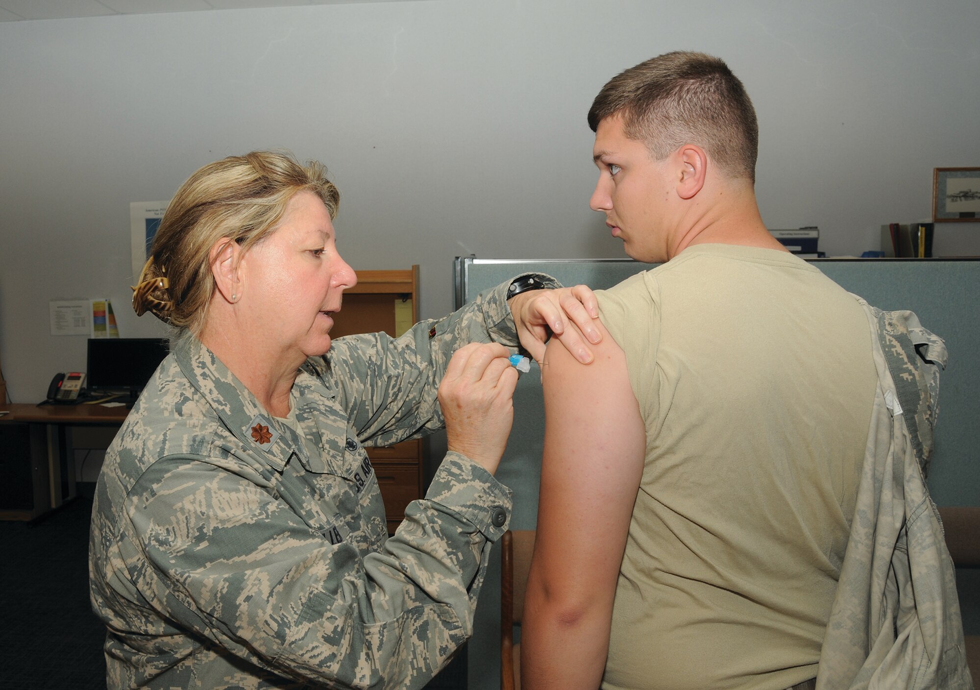 WRIGHT-PATTERSON AIR FORCE BASE, Ohio – Maj.  Karen Keller, 445th Aeromedical Staging Squadron, administers an influenza vaccine to a 445th Airlift Wing Airman for the 2014-15 flu season. The vaccination was administered to wing reservists during the October 2014 unit training assembly. Flu shots cannot prevent all cases of flu, but it is the best defense against the disease. It takes about two weeks for the body to develop protection after the vaccination, and the protection lasts several months to one year. (U.S. Air Force Photo by Tech. Sgt. Anthony G. Springer)
