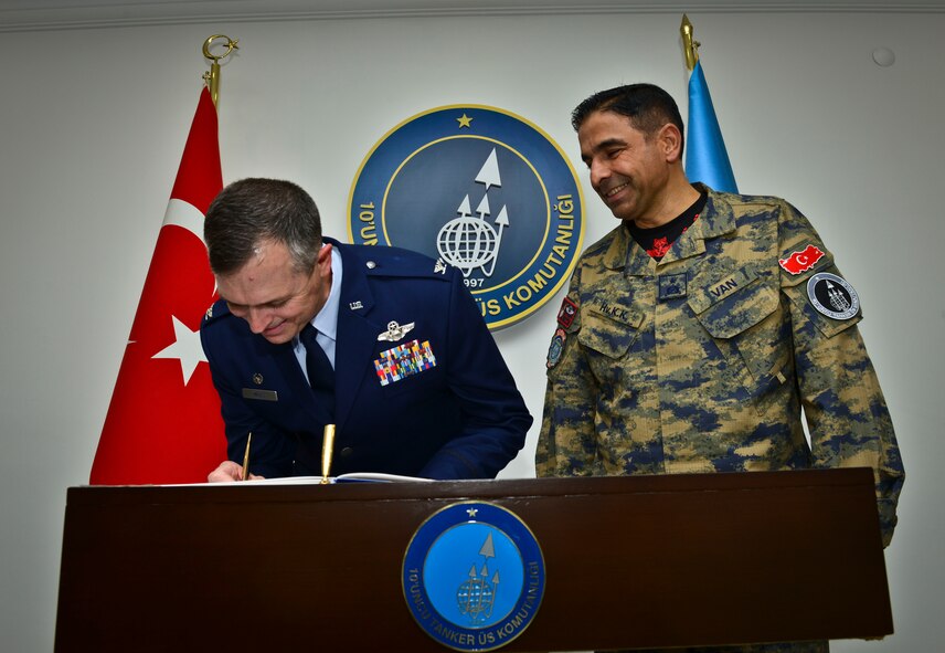 Col. Craig Wills, 39th Air Base Wing commander signs the 10th Tanker Base Command guest book after greeting Brig. Gen. Bekir Ercan VAN, incoming 10th TBC commander Oct. 22, 2014, Incirlik Air Base, Turkey.  VAN is serving his second tour at the 10th TBC after being assigned here in 2011-2012. (U.S. Air Force photo by Senior Airman Nicole Sikorski/Released)