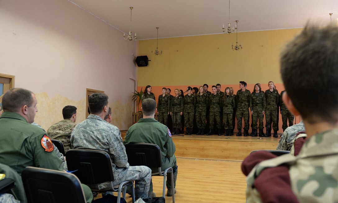 U.S. Air Force Airmen assigned to the 182nd Airlift Wing, Illinois Air National Guard, Peoria, Ill., and Detachment 1, 52nd Operations Group, from Lask Air Base, Poland, and students from Zespol Szkol Ponadgimnazjalnych W Kleczewie, a Polish high school, listen to a student performance during a school visit Oct. 21, 2014, at the school in Kleczewie, Poland. Airmen participated in class visits, a volleyball game and lunch with students during the visit. The 182nd AW is supporting rotation 15-1 hosted by the Av-Det. (U.S. Air Force photo by Airman 1st Class Dylan Nuckolls/Released)