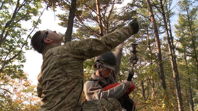 U.S. Air Force Tech. Sgt. Joseph Monreal, 51st Operations Support Squadron, holds onto the cord as Staff Sgt. Stashia Murphy, 51st Force Support Squadron formal training NCO in charge, secures herself into the harness during a combat search and rescue training scenario at an off base training site, Republic of Korea, Oct. 16, 2014. Being proficient at CSAR missions helps the teams ensure isolated personnel are able to return home safely. (U.S. Air Force photo by Senior Airman Lindy Pata/Released)