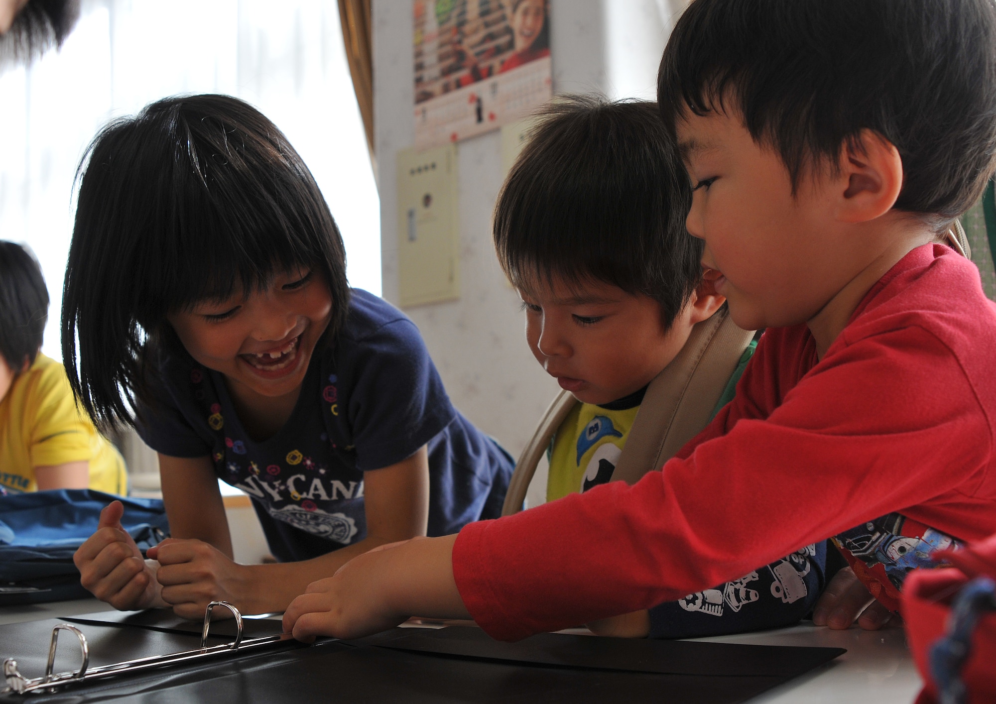 Children at the Biko-en Children’s Care House in Shichinohe, Japan, play with a binder they just received from Misawa’s First Four Organization, Oct. 18, 2014. The elementary-aged children received supplies like pencils, pens, notebooks, markers, and rulers from the 15 Airmen who visited them. (U.S. Air Force photo by Senior Airman Jose L. Hernandez-Domitilo/Released)