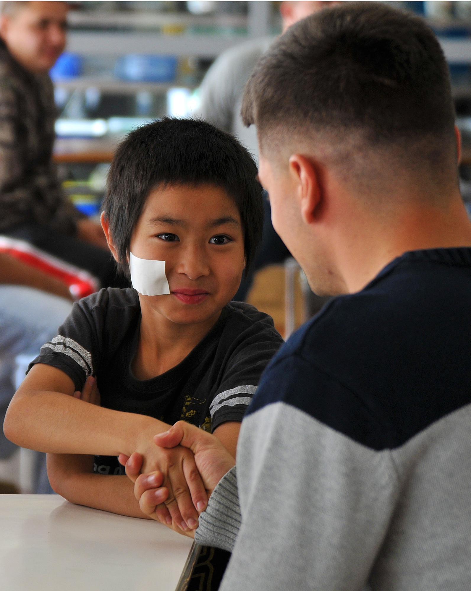 U.S. Air Force Senior Airman Christopher Russo, 35th Dental Squadron oral surgery technician, meets an orphaned child at the Biko-en Children’s Care House in Shichinohe, Japan, Oct. 18, 2014. Russo, alongside 14 other Airmen, spent the evening playing games and visiting with more than 25 children at the orphanage. (U.S. Air Force photo by Senior Airman Jose L. Hernandez-Domitilo/Released)