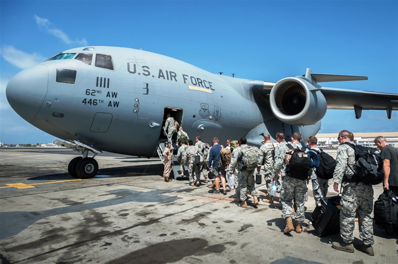 A group of 30 U.S. military personnel, including Marines, airmen, and soldiers from the 101st Airborne Division, board a U.S. Air Force C-17 Globemaster III at Léopold Sédar Senghor International Airport in Dakar, Senegal, Oct. 19, 2014. The service members were bound for Monrovia, Liberia, to construct medical treatment units and train health care workers as part of Operation United Assistance, DoD’s support to the USAID-led, whole-of-government effort to respond to the Ebola outbreak in West Africa. Air National Guard photo by Maj. Dale Greer