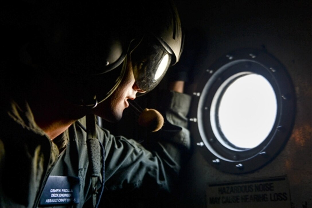 Navy Seaman Benjamin Padilla observes the cargo deck of a landing craft air cushion during joint exercise Pacific Horizon 2015, on Marine Corps Base Camp Pendleton, Calif., Oct. 24, 2014. Padilla is a gas-turbine systems technician assigned to Assault Craft Unit 5. 
