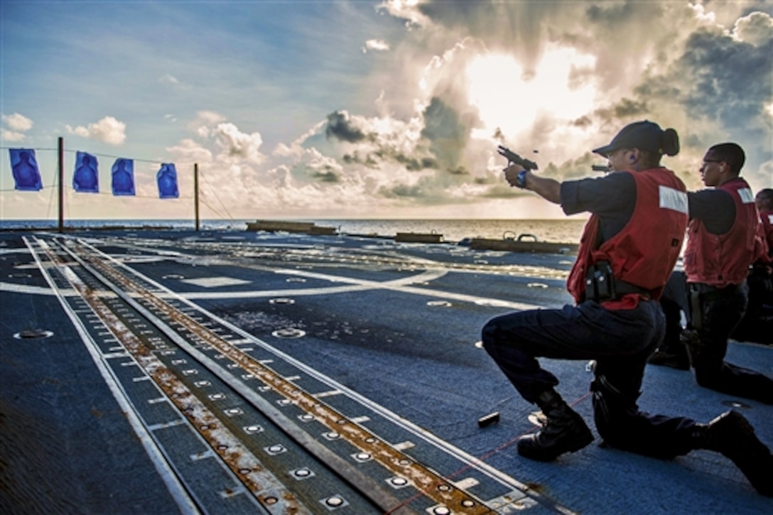 U.S. Navy Seaman Janaya Johnson fires a 9 mm pistol during small arms training on the flight deck of the guided-missile destroyer USS Mustin, Oct. 22, 2014. The Mustin is on patrol in the U.S. 7th Fleet area of responsibility supporting regional security and stability in the Indo-Asia-Pacific region. 