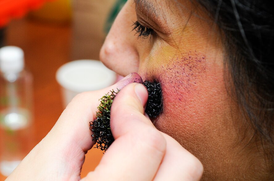 Tech. Sgt. Kim Gonzalez, 1st Special Operations Aerospace Medicine Squadron environmental health NCO in charge, has make-up applied to simulate a black eye on Hurlburt Field, Fla., Oct. 23, 2014. Gonzalez participated as one of the simulated victims in support of the Black Eye Campaign, which promoted domestic violence awareness.  (U.S. Air Force photo/Airman 1st Class Andrea Posey)