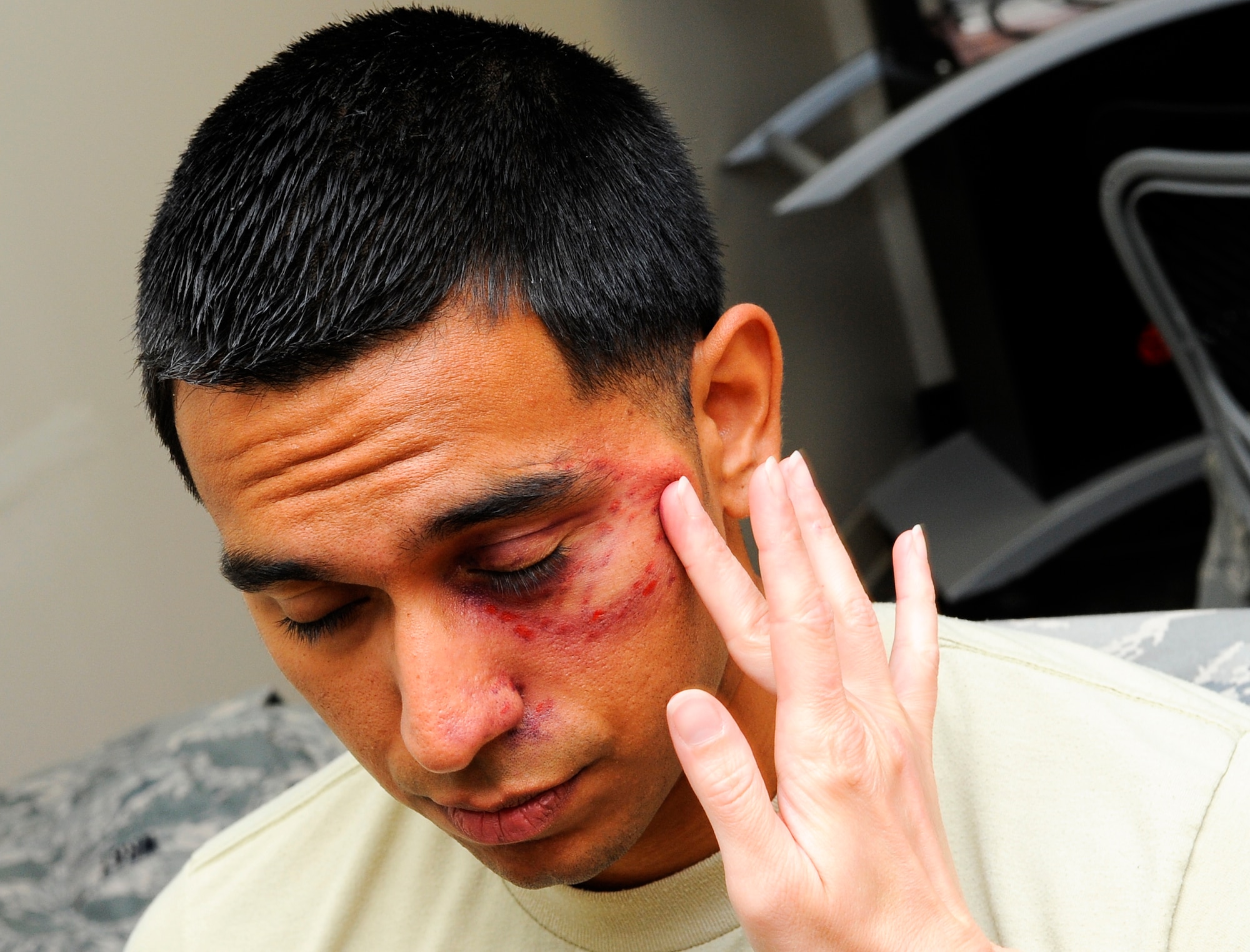 Airman 1st Class Rufino Coronado, 1st Special Operations Aerospace Medicine Squadron environmental engineering technician, has make-up applied to simulate a black eye on Hurlburt Field, Fla., Oct. 23, 2014. Coronado is the first male, here, to participate in the Black Eye Campaign, which promoted domestic violence awareness. (U.S. Air Force photo/Airman 1st Class Andrea Posey)