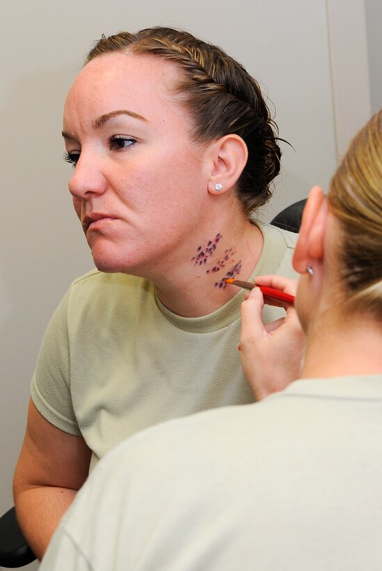 Staff Sgt. Sarah Carr, 1st Special Operations Aerospace Medicine Squadron occupational health NCO in charge, has make-up applied to simulate bruises on Hurlburt Field, Fla., Oct. 23, 2014. Carr participated as a simulated victim in support of the Black Eye Campaign, which promoted domestic violence awareness (U.S. Air Force photo/Airman 1st Class Andrea Posey)