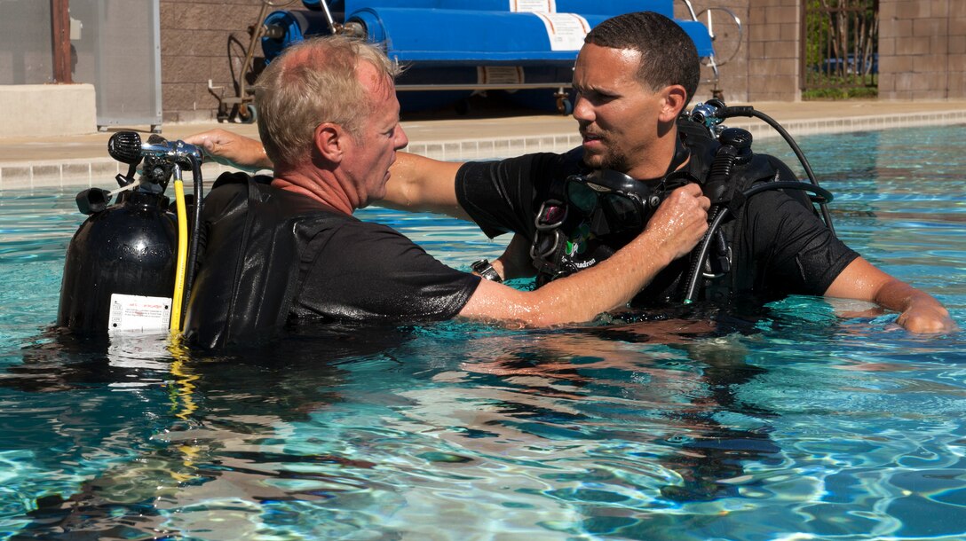 Michael Gray, 24th Special Operations Wing water operations instructor, inspects Johnnie Yellock’s, retired Staff Sgt. and 23rd Special Tactics Squadron combat controller, buoyancy control device during SCUBA-Pool Emergency Procedures training on Hurlburt Field, Fla. Oct. 21, 2014. The training is commonly used as a refresher to familiarize Airmen with life support equipment not used in daily activities and highlight the dangers associated with a high-risk activity like scuba diving. (U.S. Air Force photo/Senior Airman Kentavist P. Brackin)