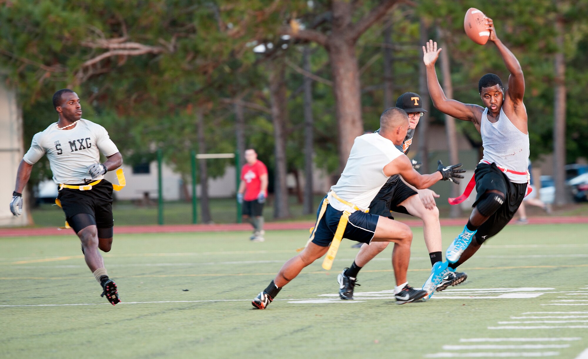 Derrick Raley, 1st Special Operations Force Support Squadron quarterback, attempts to dodge defensive linemen during an intramural flag football game on Hurlburt Field, Fla., Oct. 21, 2014. The 1st SOFSS team finished as a finalist in the 2013 Flag Football Tournament. (U.S. Air Force photo/Senior Airman Kentavist P. Brackin)