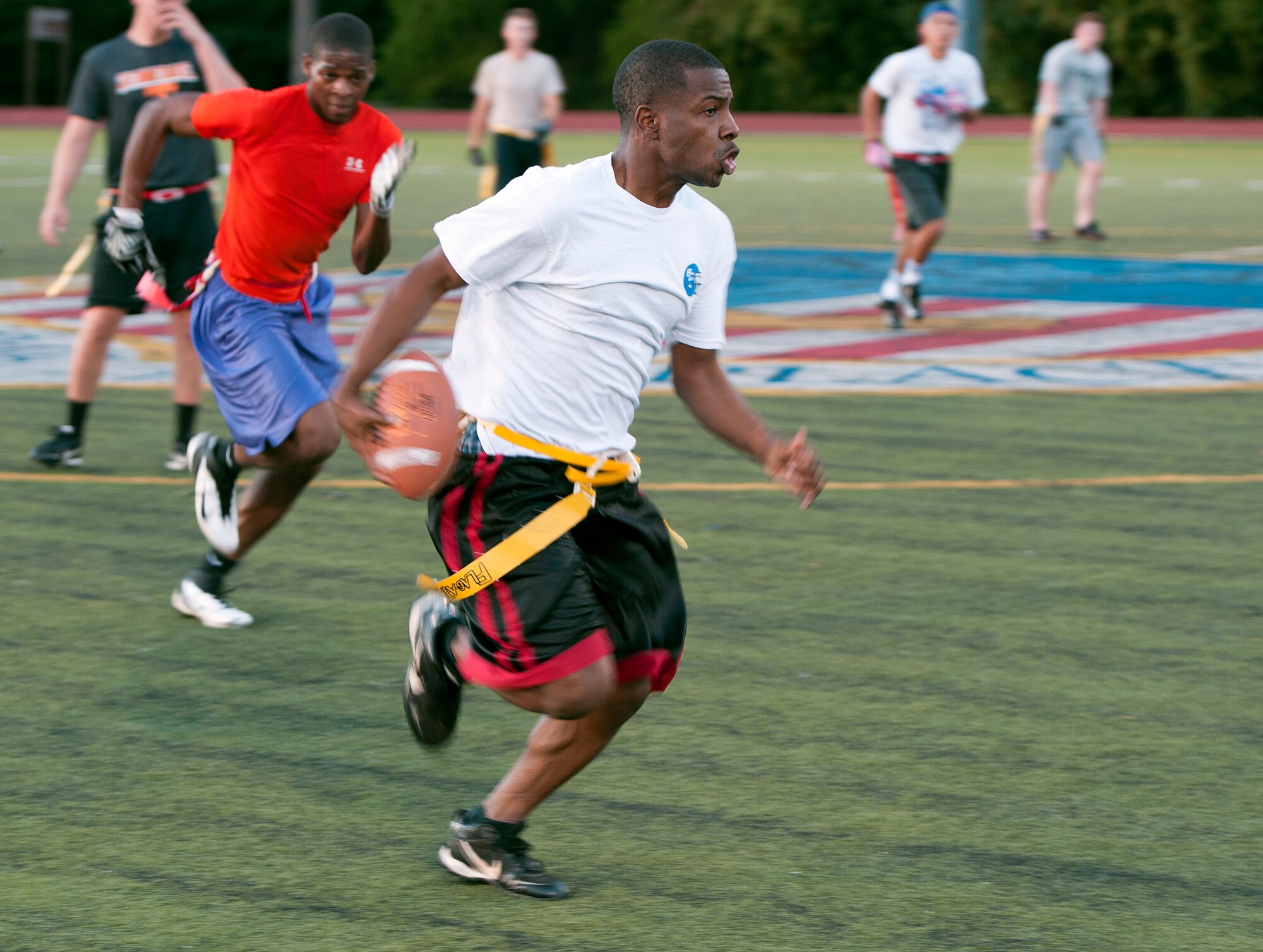 Al Sapp, 1st Special Operations Force Support Squadron wide receiver, attempts to outrun defenders during an intramural flag football game on Hurlburt Field, Fla., Oct. 21, 2014. The two teams ended the second half with a tie score of 24-24, which resulted in overtime play. (U.S. Air Force photo/Senior Airman Kentavist P. Brackin)