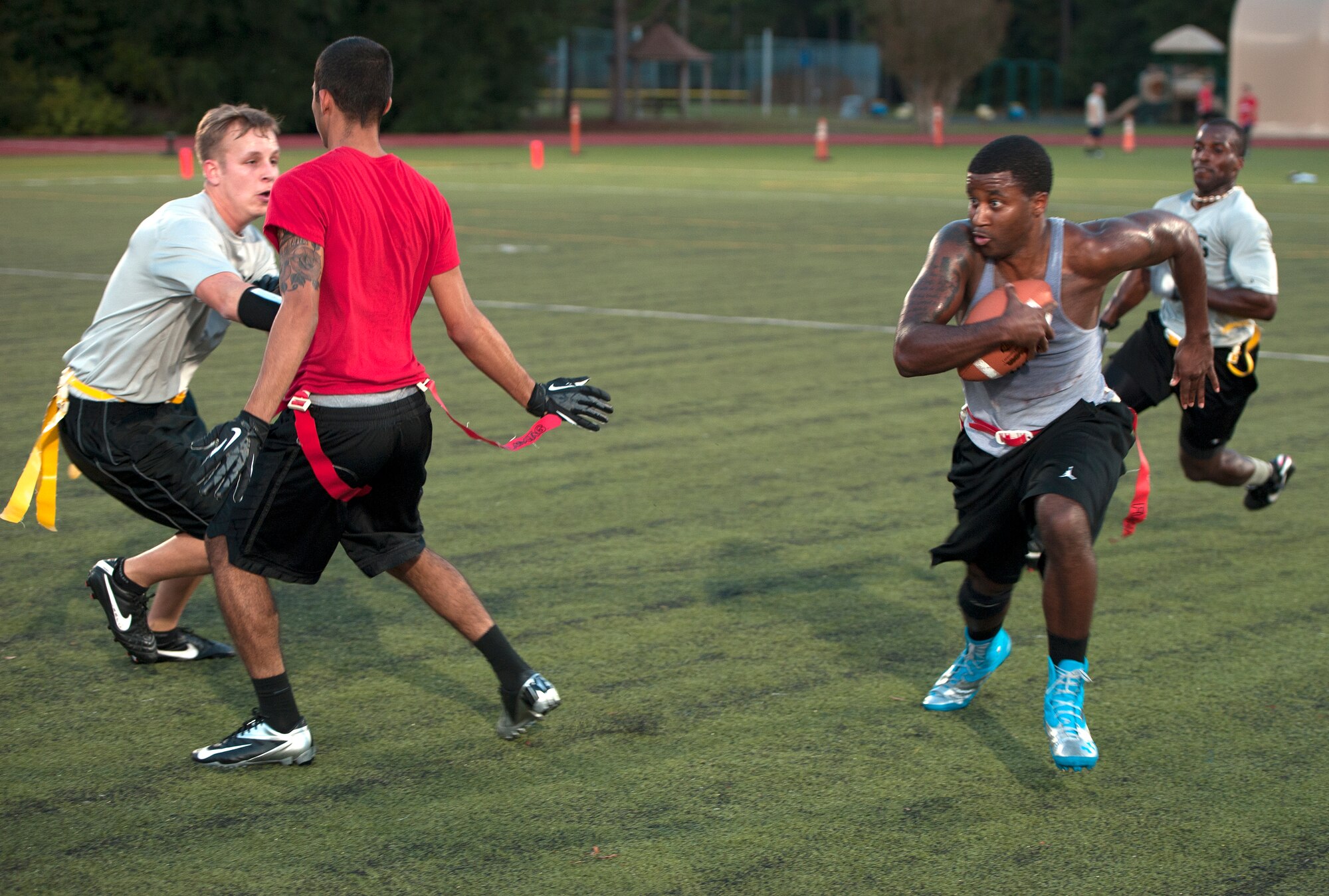 Derrick Raley, 1st Special Operations Force Support Squadron quarterback, dashes through defensive linemen during an intramural flag football game on Hurlburt Field, Fla., Oct. 21, 2014. The 1st SOFSS team finished as a finalist in the 2013 Flag Football Tournament. (U.S. Air Force photo/Senior Airman Kentavist P. Brackin)
