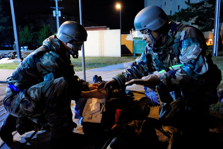 Wolf Pack Airmen perform Self-Aid and Buddy Care techniques on a simulated victim of an enemy attack during Exercise Beverly Midnight 15-1 at Kunsan Air Base, Republic of Korea, Oct. 23, 2014. This four-day exercise demonstrated the Wolf Packs ability to work alongside ROK air force allies as well as their capability of responding to wartime and armistice threats. (U.S. Air Force photo by Senior Airman Taylor Curry/Released)